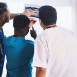 three person looking at x ray result