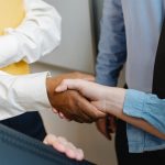 multiracial colleagues shaking hands at work