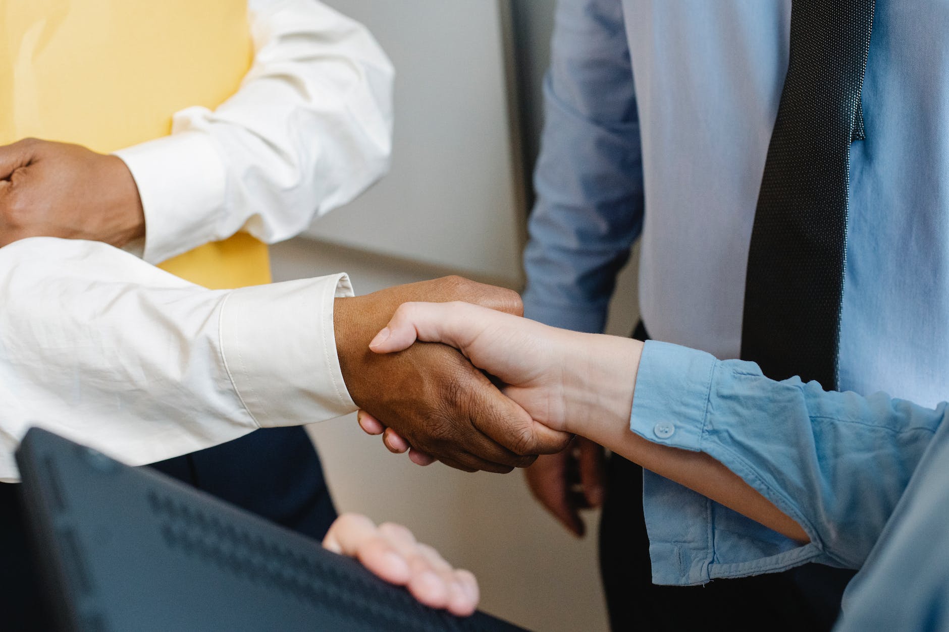 multiracial colleagues shaking hands at work